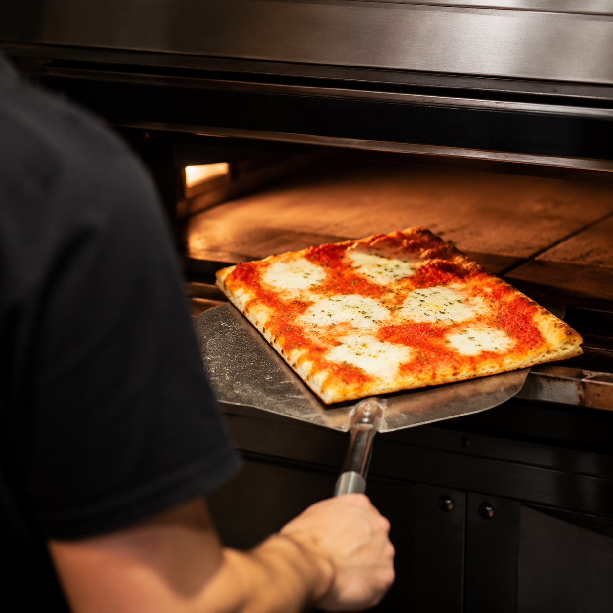 Pizza artesanal entrando en el horno eléctrico de La Gustosa II